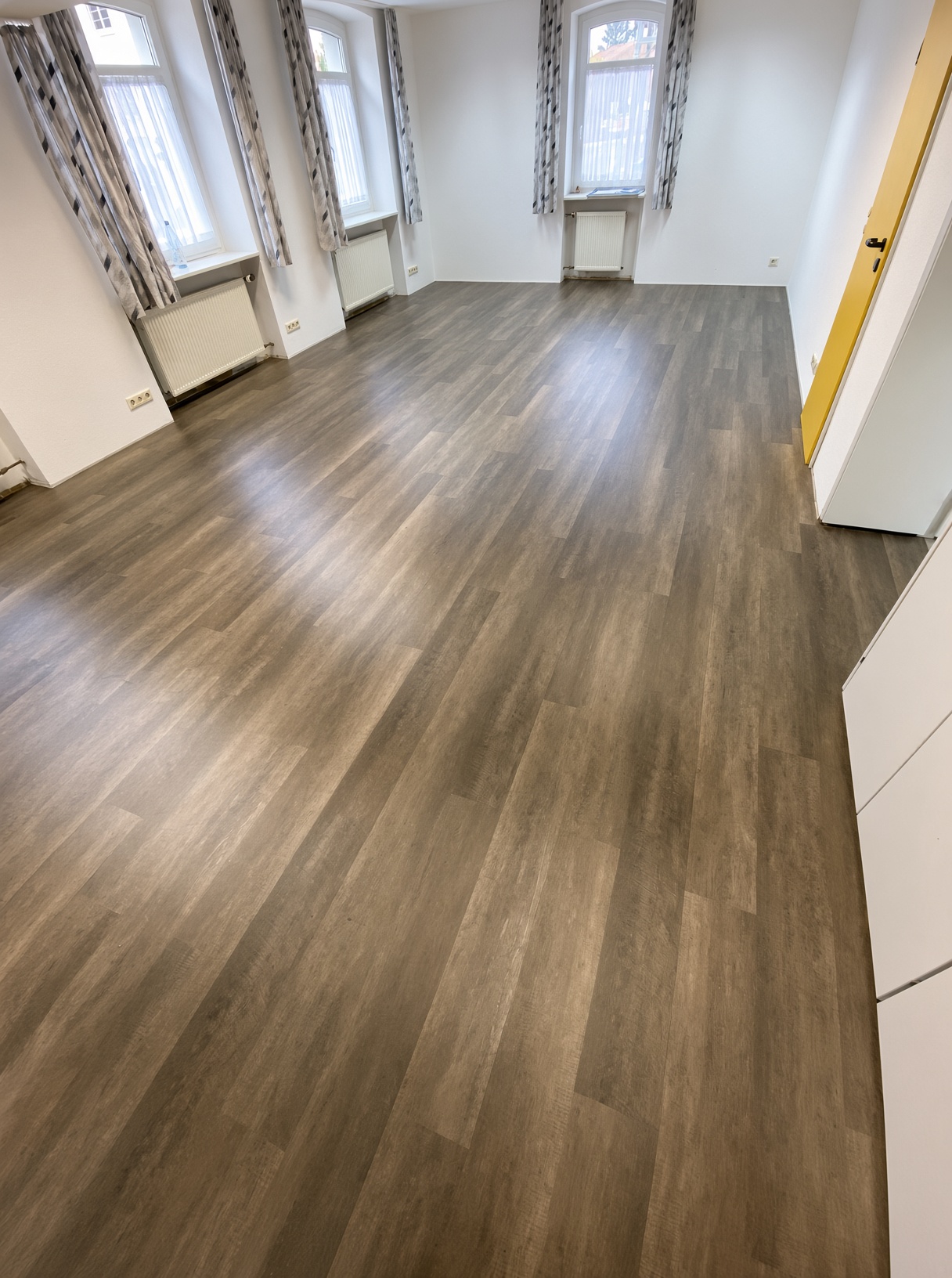 Heller Raum mit neu verlegtem Vinylboden in Holzoptik